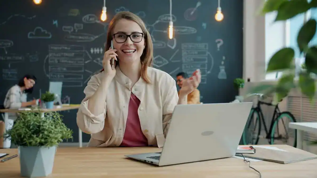 Kvinne i telefonsamtale på moderne kontor
