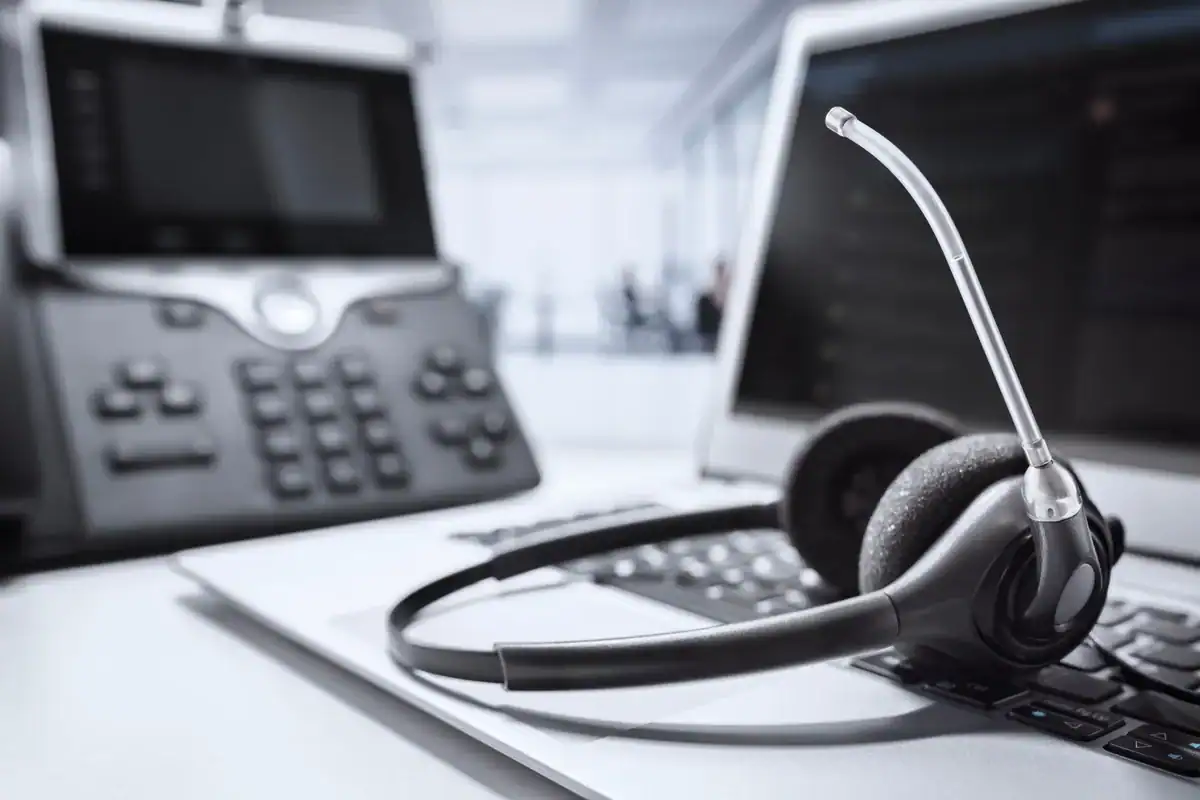 Hodesett, bærbar PC og kontortelefon på et skrivebord
